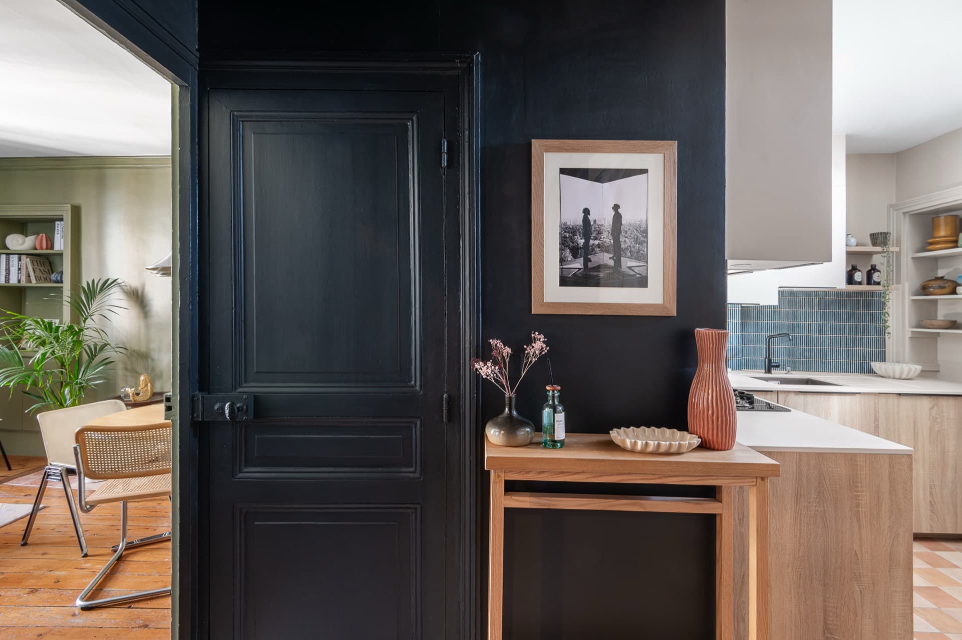 Cuisine ouverte sur mur bleu nuit avec îlot en bois et crédence en zellige, rénovation d'appartement à Dinard par Studio Songe